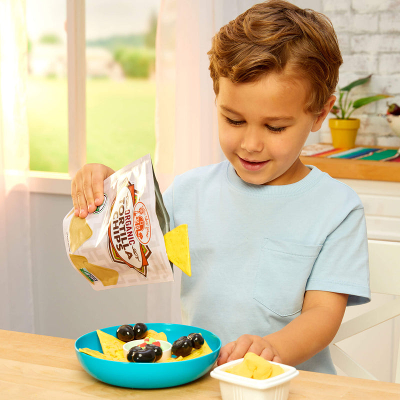 boy adding nachos to bowl