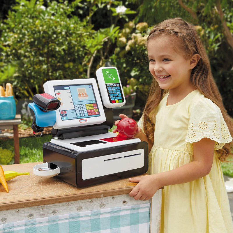 Girl standing by check out sitting on table