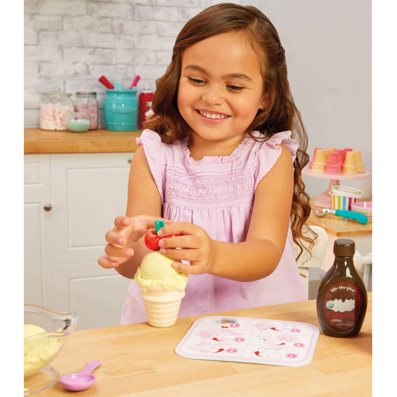 girl putting cherry on ice cream cone