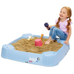 Girl sitting on seat of sandbox