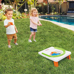 Toddler boy and girl playing cornhole